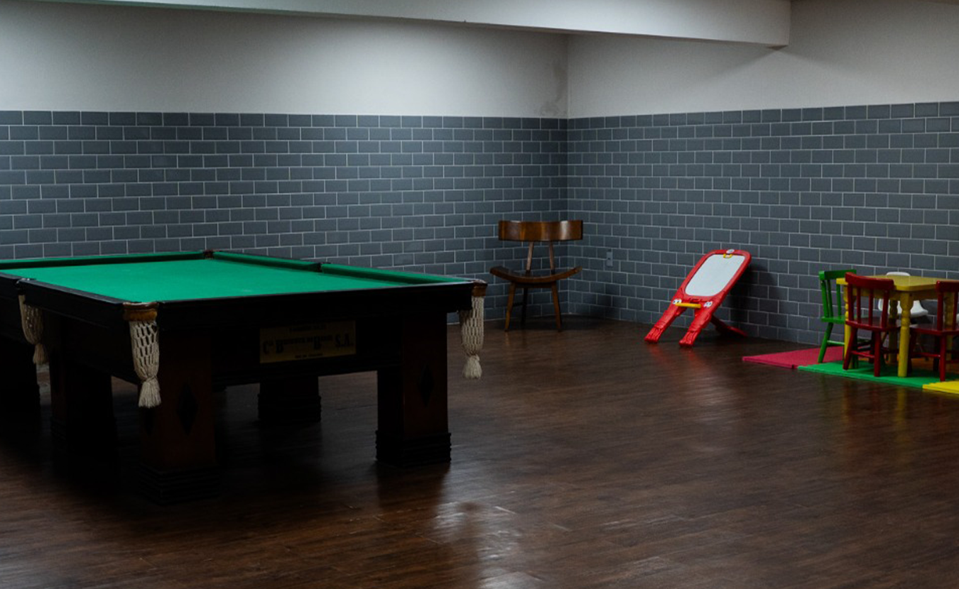 Sala de jogos com sinuca e espaço infantil